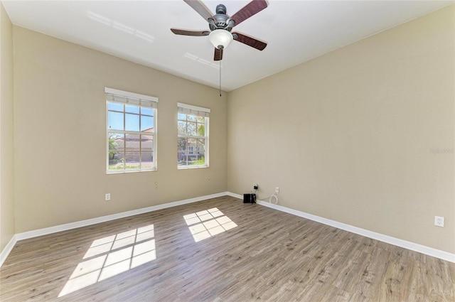 unfurnished room featuring light wood-type flooring, baseboards, and a ceiling fan