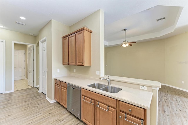 kitchen featuring visible vents, a peninsula, ceiling fan, a sink, and dishwasher
