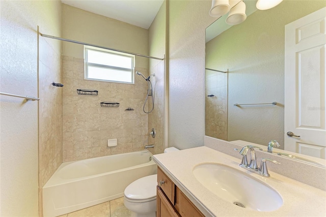 bathroom featuring tile patterned flooring, toilet, shower / bath combination, a textured wall, and vanity