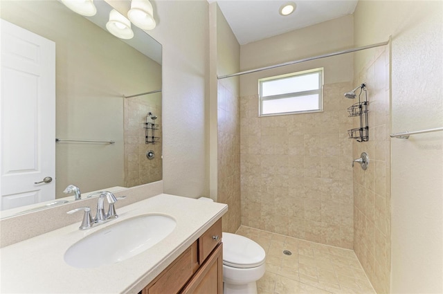 full bath featuring vanity, toilet, and tiled shower