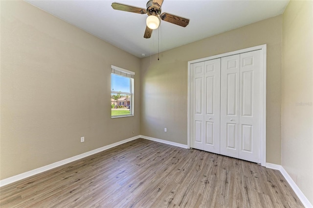 unfurnished bedroom featuring a closet, baseboards, ceiling fan, and light wood finished floors