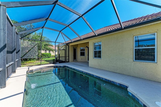 outdoor pool featuring glass enclosure and a patio