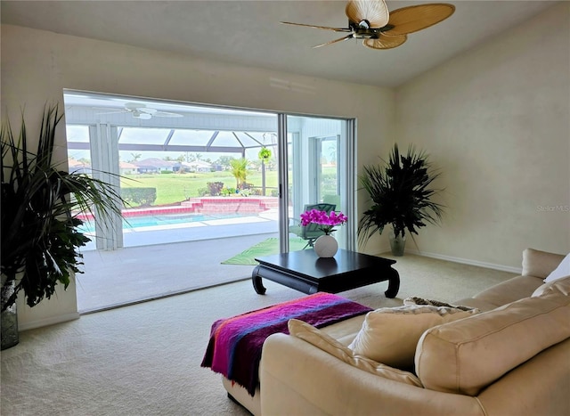 living room with ceiling fan, carpet floors, a sunroom, and baseboards
