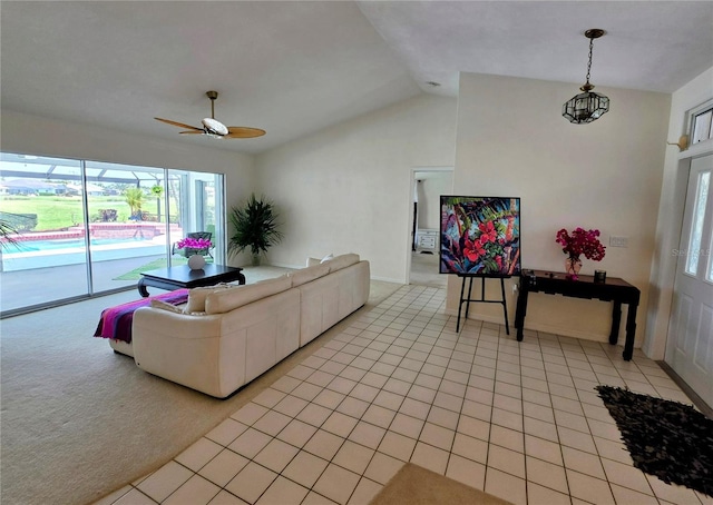 living area featuring ceiling fan, vaulted ceiling, and light tile patterned floors