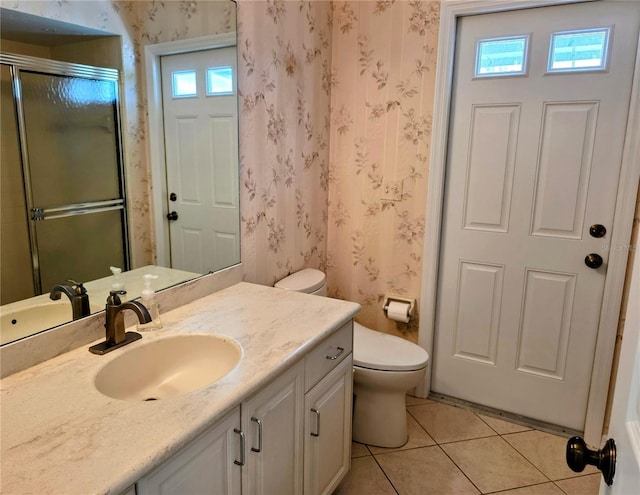 bathroom featuring toilet, a shower with door, wallpapered walls, tile patterned flooring, and vanity