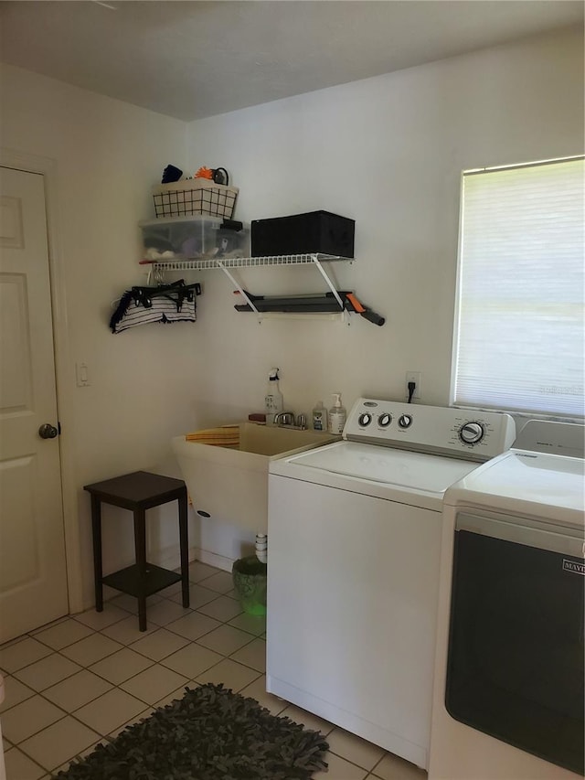 laundry area with light tile patterned flooring, washing machine and clothes dryer, a sink, and laundry area