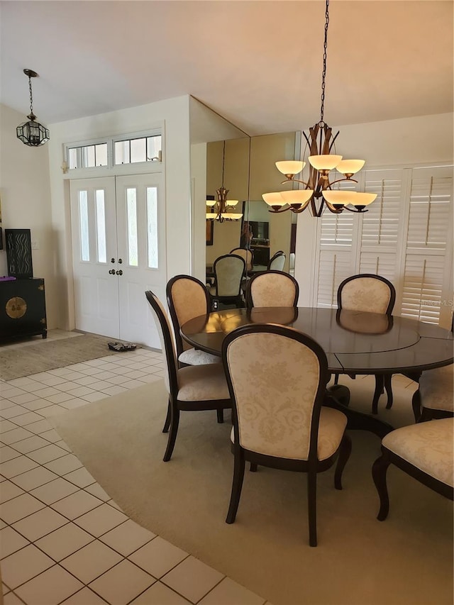dining area with an inviting chandelier, light colored carpet, and light tile patterned flooring