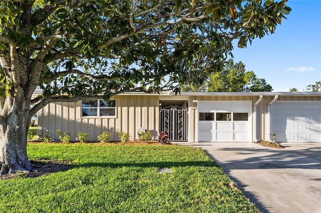 7122 11th Ave W, Bradenton, FL 34209 - view of front of house with a front lawn, concrete driveway, and board and batten siding