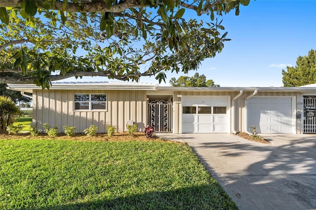 7122 11th Ave W, Bradenton, FL 34209 - view of front of house featuring board and batten siding, an attached garage, driveway, and a front yard