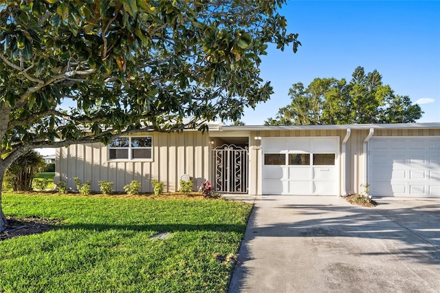 7122 11th Ave W, Bradenton, FL 34209 - view of front of property featuring a front lawn, a garage, board and batten siding, and driveway