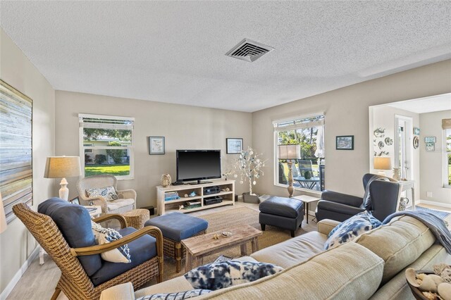 7122 11th Ave W, Bradenton, FL 34209 - living room with visible vents, a textured ceiling, and baseboards