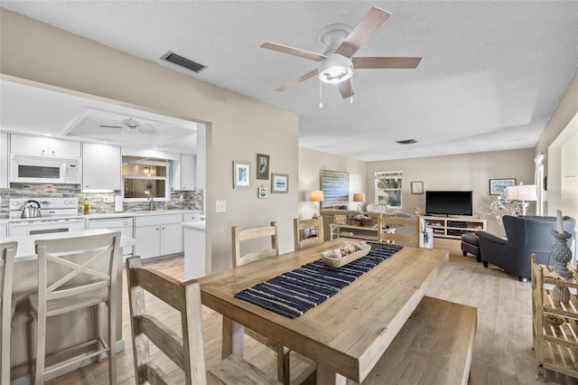 7122 11th Ave W, Bradenton, FL 34209 - dining area with visible vents, a textured ceiling, light wood-style floors, and ceiling fan