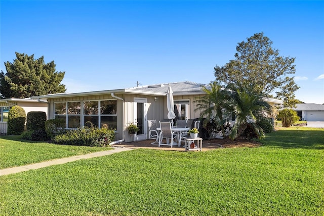 7122 11th Ave W, Bradenton, FL 34209 - back of house with a patio, a lawn, and board and batten siding