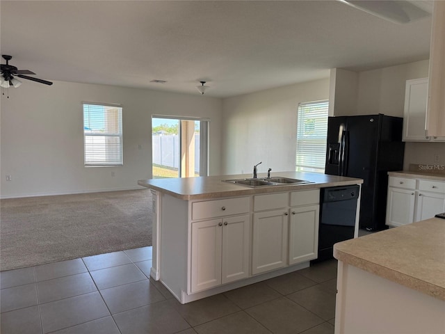 kitchen with black appliances, light carpet, open floor plan, and a sink