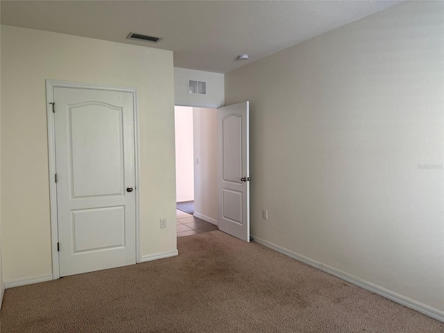 unfurnished bedroom featuring visible vents, carpet floors, and baseboards