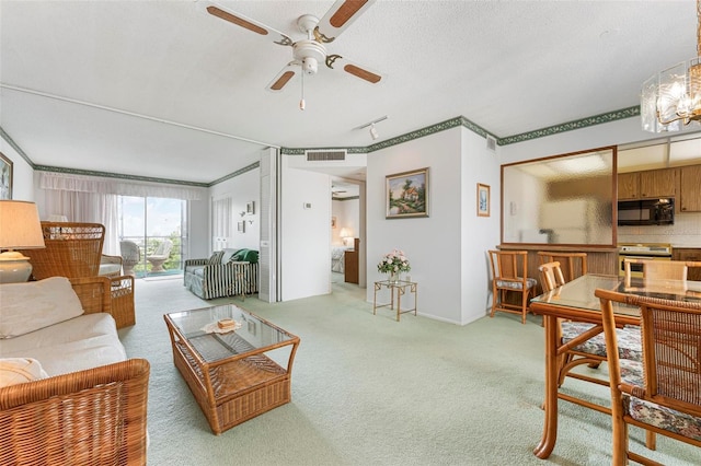 carpeted living room with ceiling fan and a chandelier