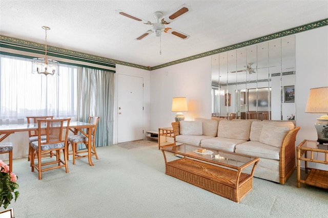 living area featuring ceiling fan, carpet flooring, and a chandelier