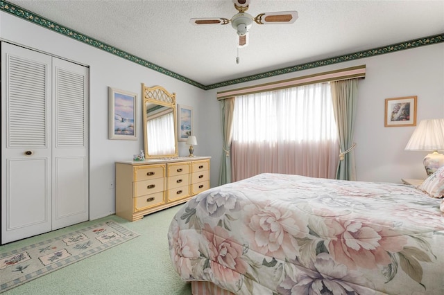 bedroom featuring light carpet, a closet, ceiling fan, and a textured ceiling