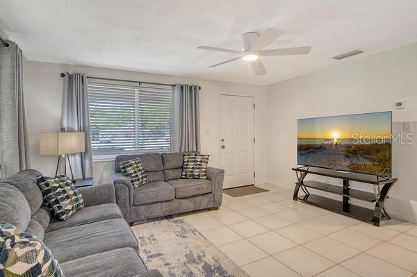 4560 Brooksdale Dr, Sarasota, FL 34232 - living area featuring light tile patterned flooring, ceiling fan, and visible vents
