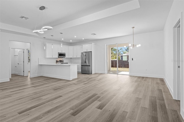 2364 Carpenter Ln, North Port, FL 34286 - kitchen featuring appliances with stainless steel finishes, a chandelier, open floor plan, light countertops, and a peninsula