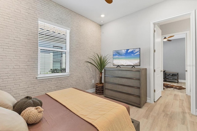 bedroom with brick wall, baseboards, recessed lighting, light wood-style floors, and a ceiling fan