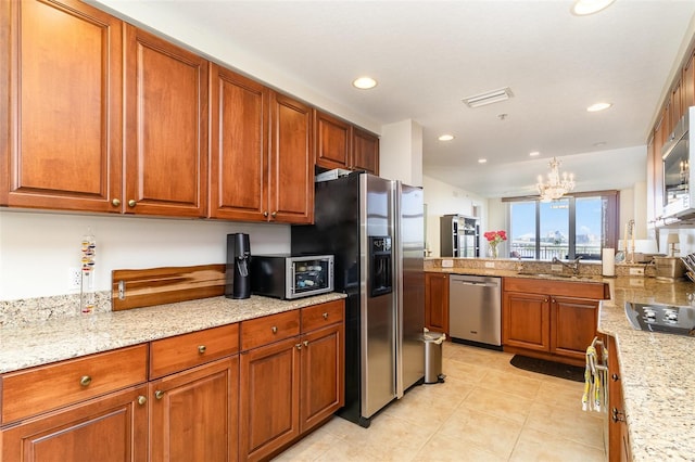 615 Riviera Dunes Way Unit 208, Palmetto, FL 34221 - kitchen with stainless steel appliances, a chandelier, brown cabinets, light tile patterned floors, and recessed lighting