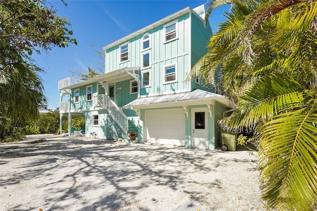 111 Faubel St, Sarasota, FL 34242 - view of front of house featuring stairs, a standing seam roof, board and batten siding, metal roof, and a garage