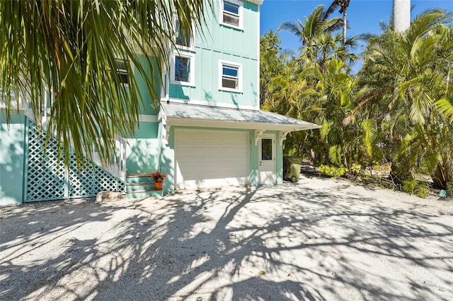 111 Faubel St, Sarasota, FL 34242 - exterior space with board and batten siding, a standing seam roof, a garage, and metal roof