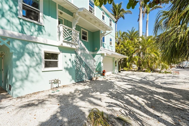 111 Faubel St, Sarasota, FL 34242 - view of side of home with driveway, a garage, and stairway