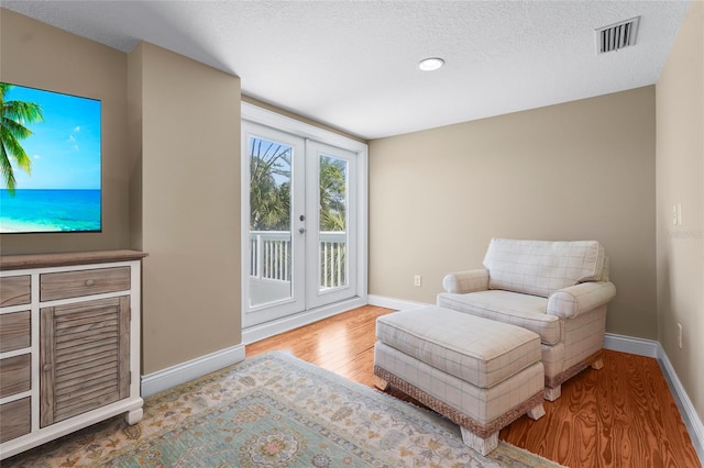 111 Faubel St, Sarasota, FL 34242 - living area with baseboards, a textured ceiling, visible vents, and wood finished floors