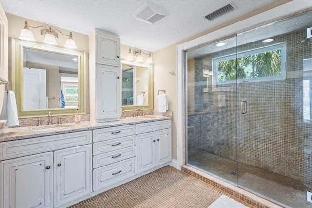 111 Faubel St, Sarasota, FL 34242 - bathroom featuring a shower stall, double vanity, visible vents, and a sink