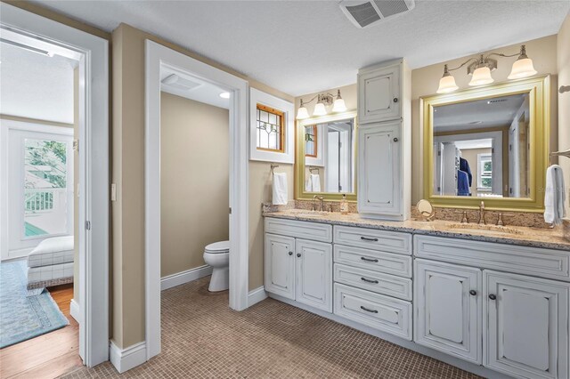 111 Faubel St, Sarasota, FL 34242 - bathroom featuring visible vents, a sink, toilet, and double vanity