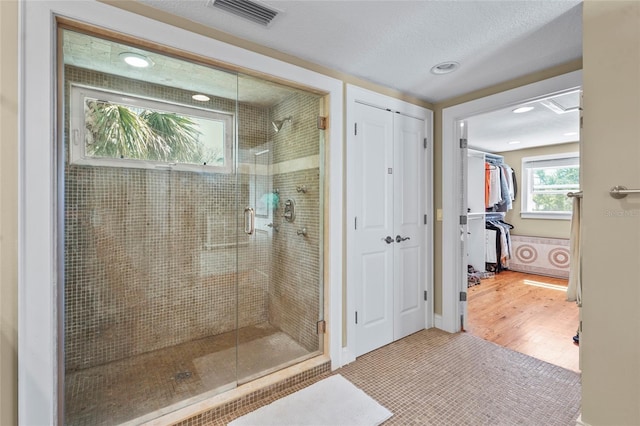 111 Faubel St, Sarasota, FL 34242 - full bath featuring a stall shower, a closet, wood finished floors, a textured ceiling, and visible vents