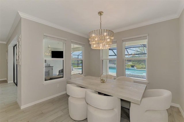dining area with baseboards, ornamental molding, a chandelier, and light wood-style floors