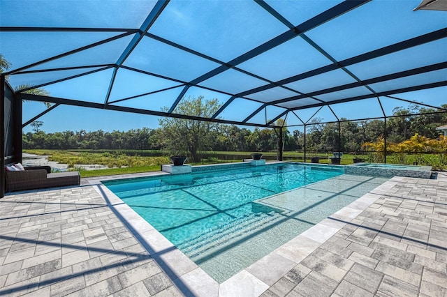 view of swimming pool featuring glass enclosure, a patio, and a pool with connected hot tub