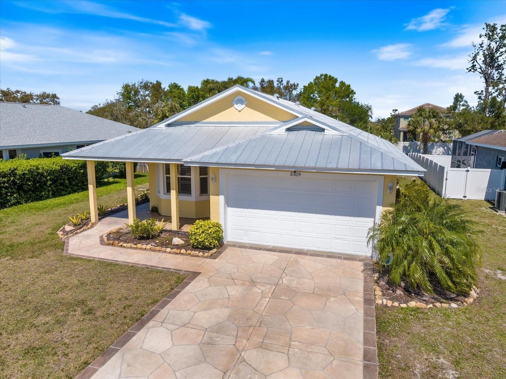 5319 Levi Ln, Sarasota, FL 34233 - view of front facade with stucco siding, concrete driveway, metal roof, and a front yard