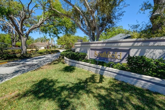community / neighborhood sign featuring a lawn