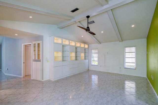 empty room with lofted ceiling with beams, ceiling fan, light tile patterned flooring, and a wealth of natural light