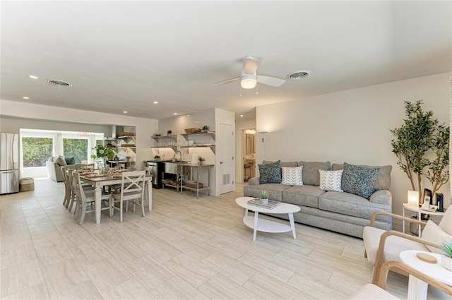 living area with visible vents, recessed lighting, and a ceiling fan