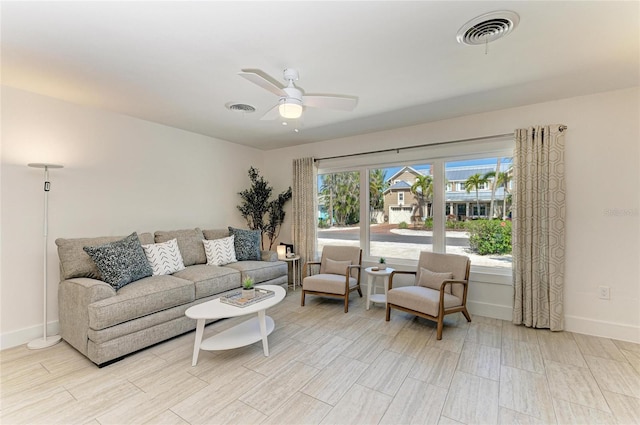 living area featuring visible vents, baseboards, and a ceiling fan