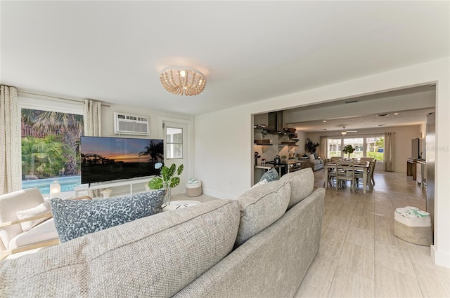 living area with baseboards and a wall mounted AC