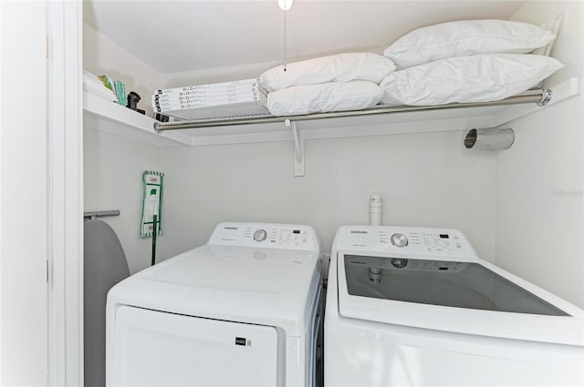 clothes washing area featuring separate washer and dryer and laundry area