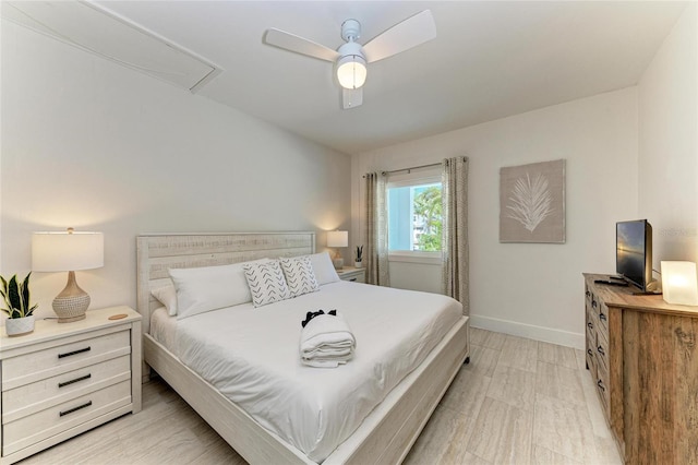 bedroom featuring attic access, a ceiling fan, and baseboards