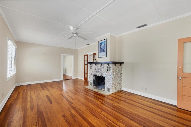 unfurnished living room featuring a ceiling fan, visible vents, wood-type flooring, a tile fireplace, and baseboards