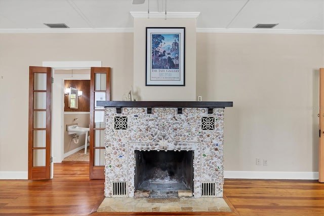 details with wood finished floors, baseboards, ornamental molding, and visible vents