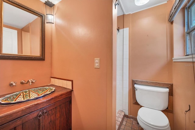 full bath featuring vanity, a tile shower, and toilet