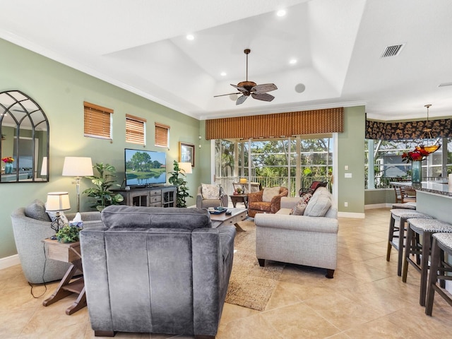 living room featuring a tray ceiling, recessed lighting, ceiling fan, and ornamental molding