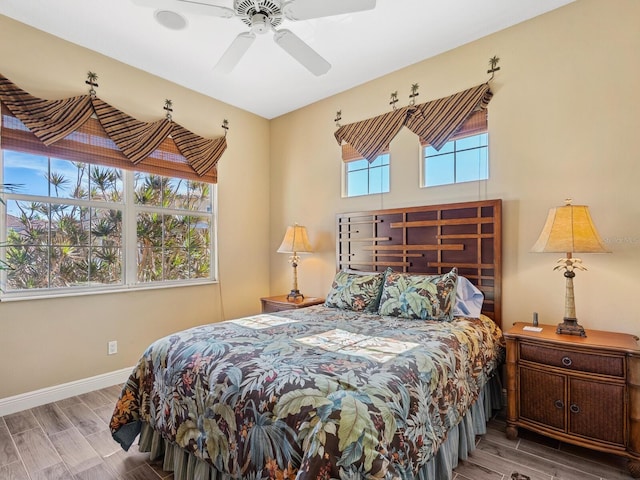 bedroom with baseboards, wood tiled floor, and a ceiling fan