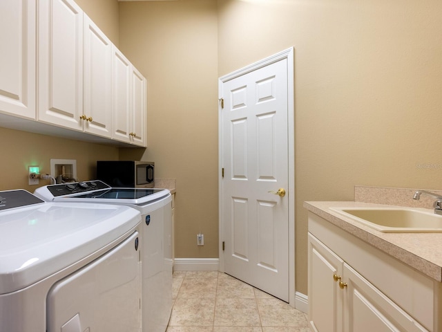 laundry area with light tile patterned flooring, a sink, baseboards, independent washer and dryer, and cabinet space
