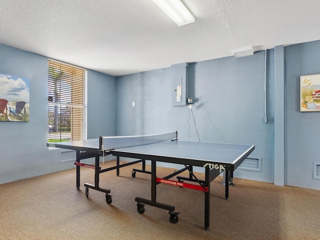 playroom with carpet flooring, visible vents, electric panel, and a textured ceiling